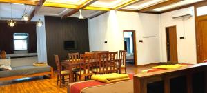 a room with a table and chairs and a dining room at Moonlight Resorts Idappadi in Ammāpettai