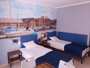 a room with two beds and a boat in the water at Hostel Annamarie in Szczecin