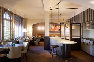 a restaurant with tables and chairs and a bar at Logis Hôtel Beauséjour Colmar in Colmar