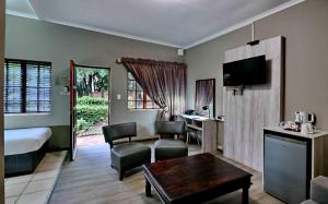 a hotel room with a bed and a desk and a room at BON Hotel Rustenburg in Rustenburg
