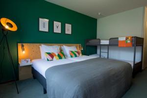 a bedroom with a large bed and a green wall at Landgoed Mennorode in Elspeet +23 photos