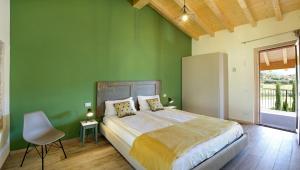 a green bedroom with a bed and a chair at Agriturismo La Rocca in Bardolino +100 photos