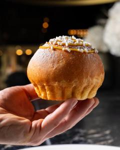 a person holding a doughnut in their hands at Savoia Hotel Rimini in Rimini