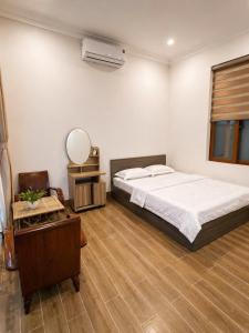 a bedroom with a bed and a vanity and a mirror at Góc Núi Homestay in Thôn Dư Khánh