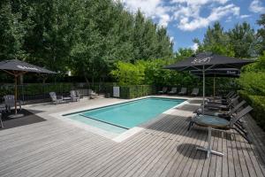 a swimming pool with umbrellas and lounge chairs and a swimming pool at Brenaissance Wine & Stud Estate in Stellenbosch