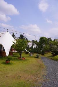 a white tent in a yard with a tree at Sa Đéc Glamping in Ấp Ðông Qứi