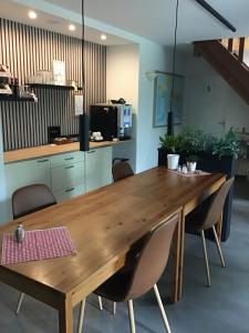 a large wooden table in a room with chairs at B&B Knooppunt70 in Arcen