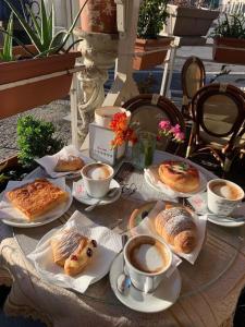 a table topped with plates of pastries and cups of coffee at La Foresteria in Mola di Bari