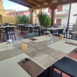 Tische und Stühle in einem Restaurant mit leeren Tischen in der Unterkunft Hotel Ogliastra in Lotzorai