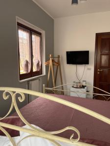 a bedroom with a bed and a window and a tv at Piccola Mansarda in Parghelia +25 photos
