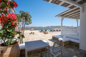 a patio with a table and chairs on the beach at Yakinthos Suites in Mykonos