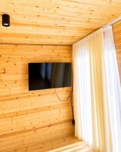 a television in a room with a wooden wall at Achkhoti Paradise in Kazbegi