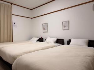 two beds sitting next to each other in a room at ura San Jose トリプルルーム in Okayama +23 photos