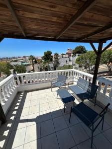 a patio with two chairs and a table on a balcony at Casa Atalaya Playa R&R in Aguadulce