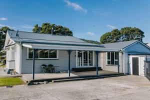 a blue and white house with a patio at Marsden Manor - Spacious house with large pool in Greymouth