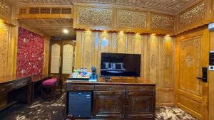 a room with a desk and a tv in a room at Suroor Houseboat in Srinagar