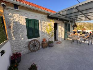 a patio of a house with a table and chairs at Vranac Country house Šibenik in Donje Polje