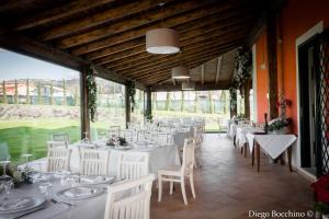 a dining room with white tables and white chairs at Agriturismo Villa Luisa in Apice