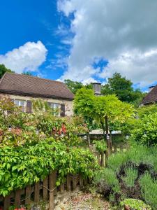 a garden in front of a house with a fence at Joli Canard in Badefols-dʼAns