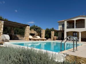 a large swimming pool in front of a house at Onirozo Koroni Private Villa in Koroni