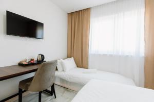 ein Schlafzimmer mit Schreibtisch, Bett und Stuhl in der Unterkunft Rustikana doo in Livno