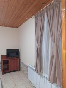 a living room with a television and a window at Стария Чинар in Melnik