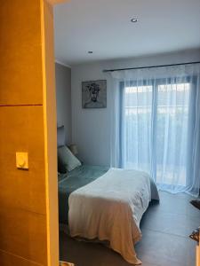 a bedroom with a bed and a large window at Villa , Piscine Privée, Jacuzzi in Barbaggio +35 photos