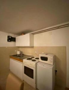 a kitchen with a white stove and a sink at Apartmani Benjamin in Tuzla +7 photos