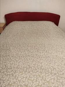 a bed with a white comforter on top of it at Apartmani Benjamin in Tuzla