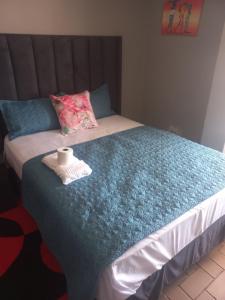 a bedroom with a bed with a towel on it at Tourist Guest House Accommodation in Mahikeng