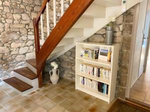 a staircase with a book shelf with books at Le Logis de la Forge-10min puydufou in Mortagne-sur-Sèvre