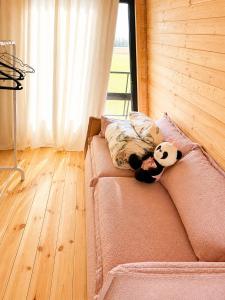 a stuffed panda bear laying on a couch at Achkhoti Paradise in Kazbegi