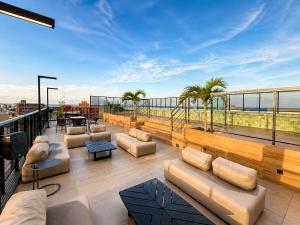 a rooftop patio with couches and a view of the ocean at Emunah Flat Luxo Cabedelo • Piscina no Rooftop in Cabedelo