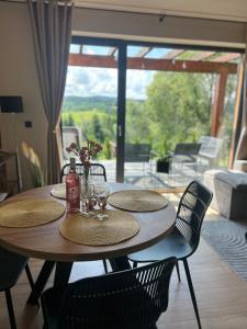 a dining room table with chairs and a view of a patio at Stodoły ForRest in Czarna