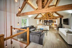 a living room with couches and a dining room at Lower Tundridge Cottage in Worcester