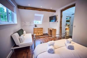 a small bedroom with two beds and a chair at Lower Tundridge Cottage in Worcester