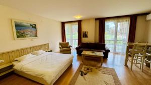a bedroom with a bed and a chair and a table at студио Пирин in Razlog