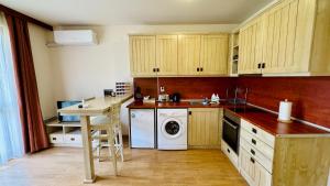 a kitchen with wooden cabinets and a washer and dryer at студио Пирин in Razlog
