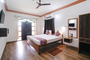 a bedroom with a bed and a mirror in it at Via Romeo's Stay - A Beach Property in Baga