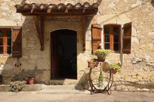 a bike parked in front of a building with a door at La ferme des Perdilles in Biran