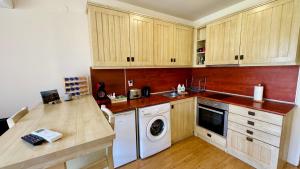 a kitchen with wooden cabinets and a washer and dryer at студио Пирин in Razlog