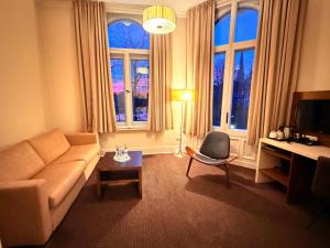 a living room with a couch and a table at Hotel Excellent in Lübeck
