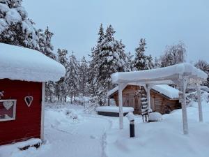 ashed covered in snow next to a cabin at Red House at Kuusitie in Kittilä