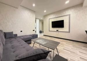 a living room with a couch and a tv at Republic Square Modern Flat in Yerevan