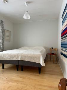a bedroom with a bed in a white room at Red House at Kuusitie in Kittilä