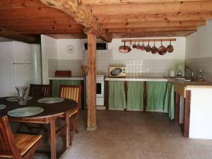 a kitchen with a table and some green cabinets at La ferme des Perdilles in Biran +6 photos