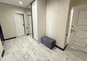a empty room with a door and a blue ottoman at Republic Square Modern Flat in Yerevan