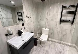 a white bathroom with a sink and a toilet at Republic Square Modern Flat in Yerevan