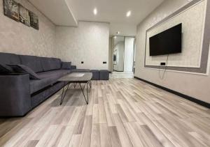 a living room with a couch and a flat screen tv at Republic Square Modern Flat in Yerevan +3 photos