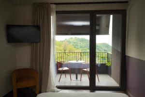 a room with a view of a balcony with a table and chairs at El Cielo - Rooms with Panoramic View & El Carnicero Restaurant in Cornedo Vicentino